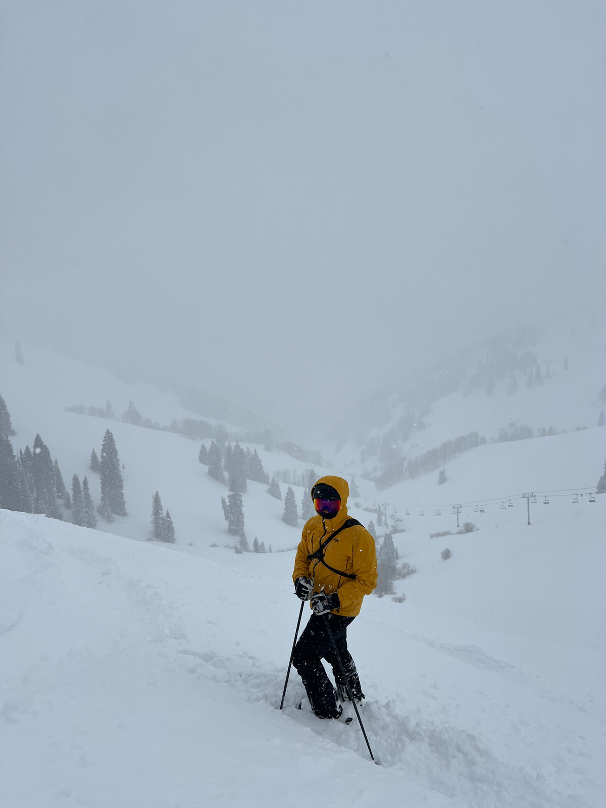 Skier in a yellow jacket on a snowy slope, wearing the Switchbak 14